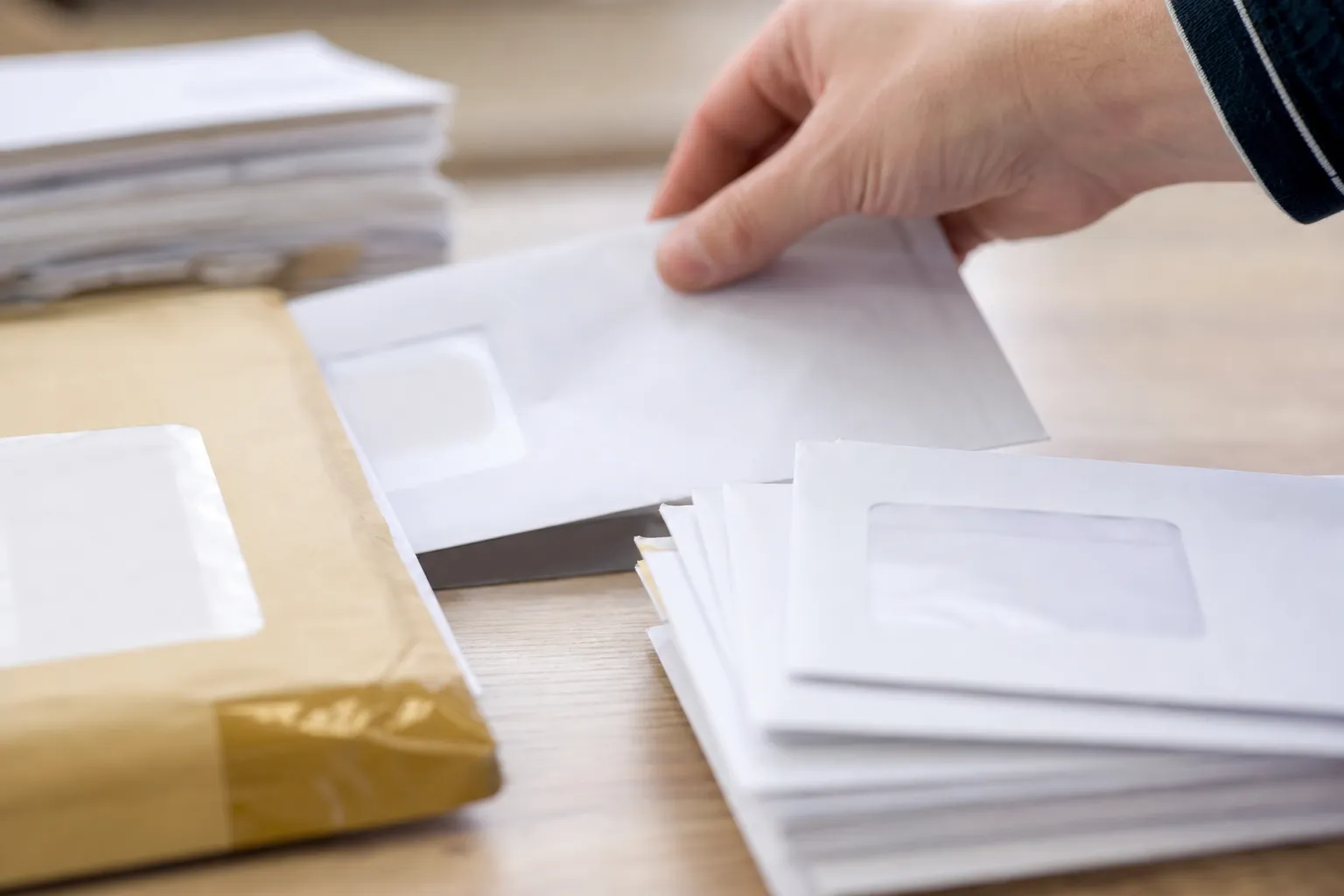 Enveloppes de courrier professionnel et un pli recommandé triés à la main sur un bureau