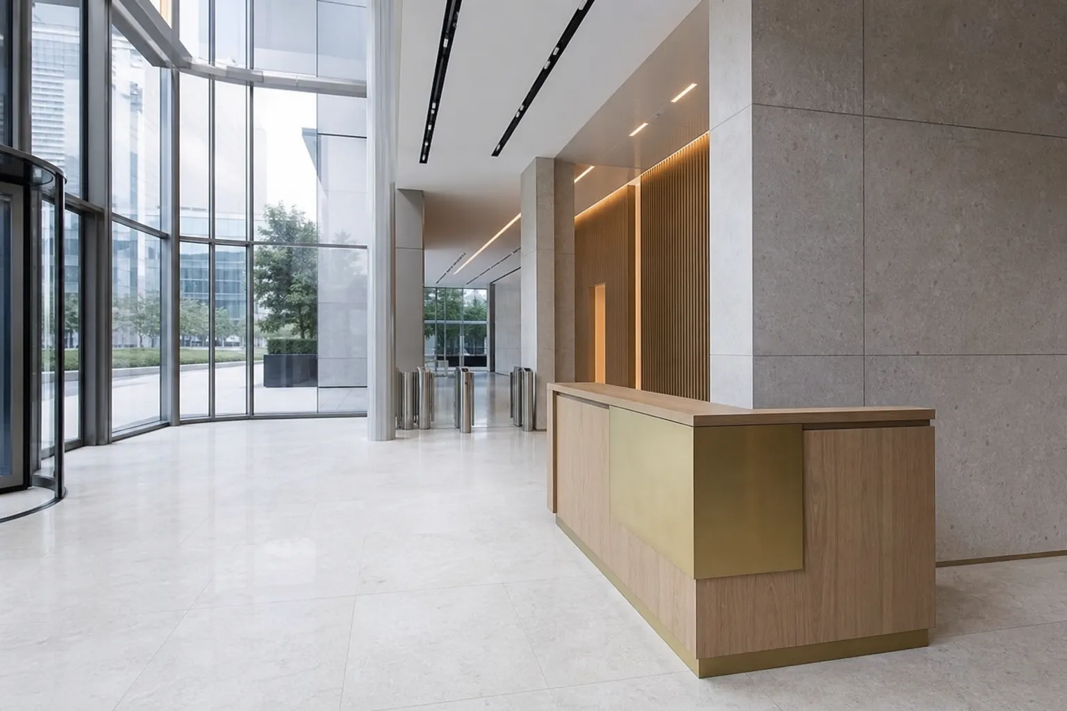 Hall d’entrée sobre d’un immeuble de bureaux contemporain, banque d’accueil en bois clair